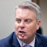 Dirigente de terno azul fala ao microfone em audiência; imagem da notícia sobre fiscalização de bets e a eleição de Fabio Macorin na IAGR