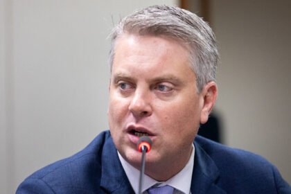 Dirigente de terno azul fala ao microfone em audiência; imagem da notícia sobre fiscalização de bets e a eleição de Fabio Macorin na IAGR