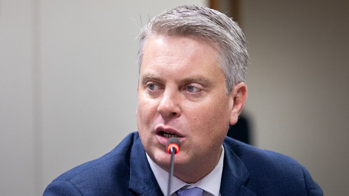 Dirigente de terno azul fala ao microfone em audiência; imagem da notícia sobre fiscalização de bets e a eleição de Fabio Macorin na IAGR