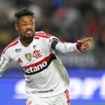 Atacante do Flamengo de uniforme branco comemora gol apontando para a torcida, antes de Flamengo x Del Valle pela Libertadores