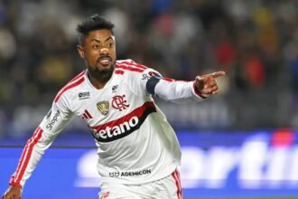 Atacante do Flamengo de uniforme branco comemora gol apontando para a torcida, antes de Flamengo x Del Valle pela Libertadores