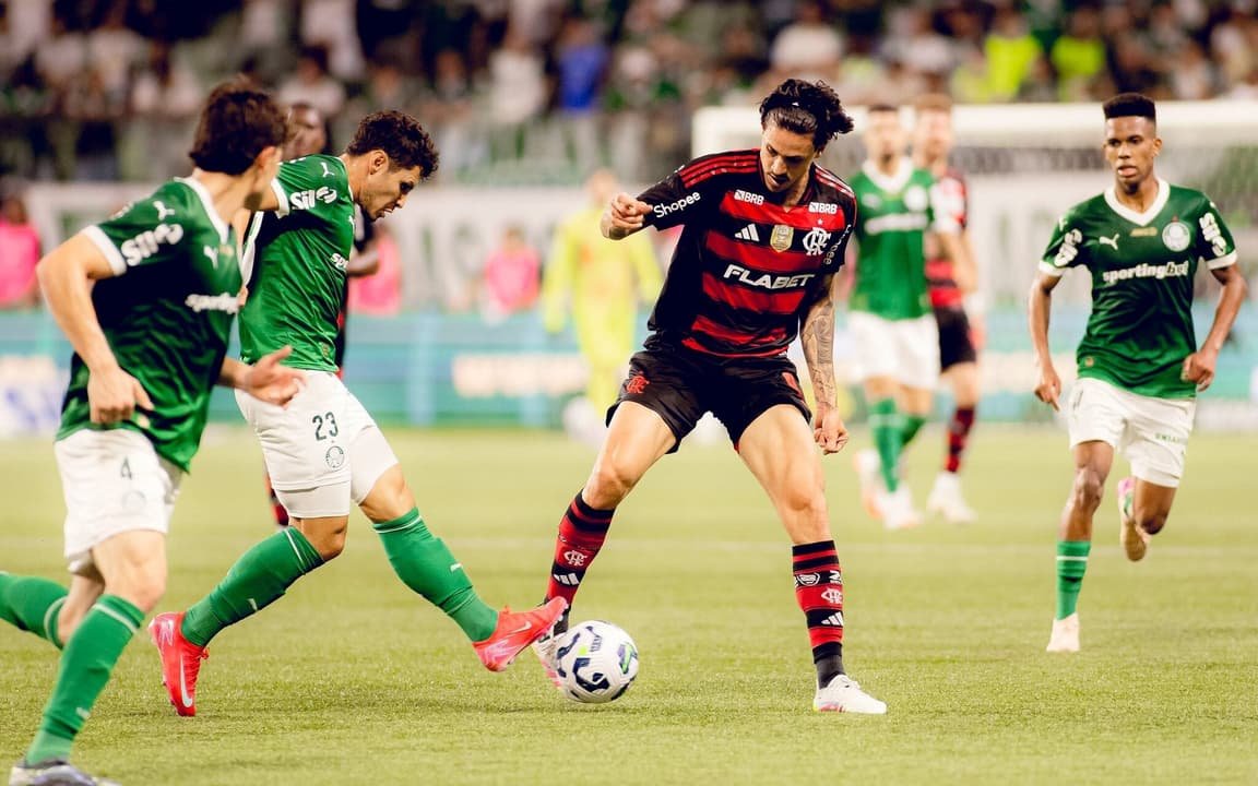 Jogadores de Flamengo e Palmeiras disputam a bola em partida do Brasileirão